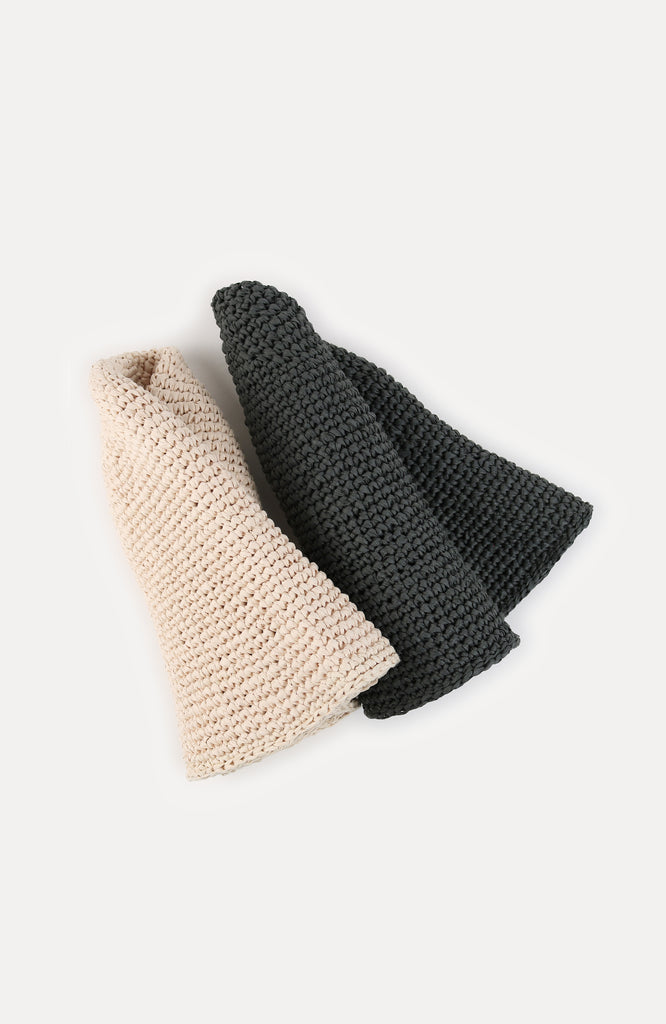 two crochet paper sun hats in ivory and thyme colour from Karakoram Accessories rolled on white background