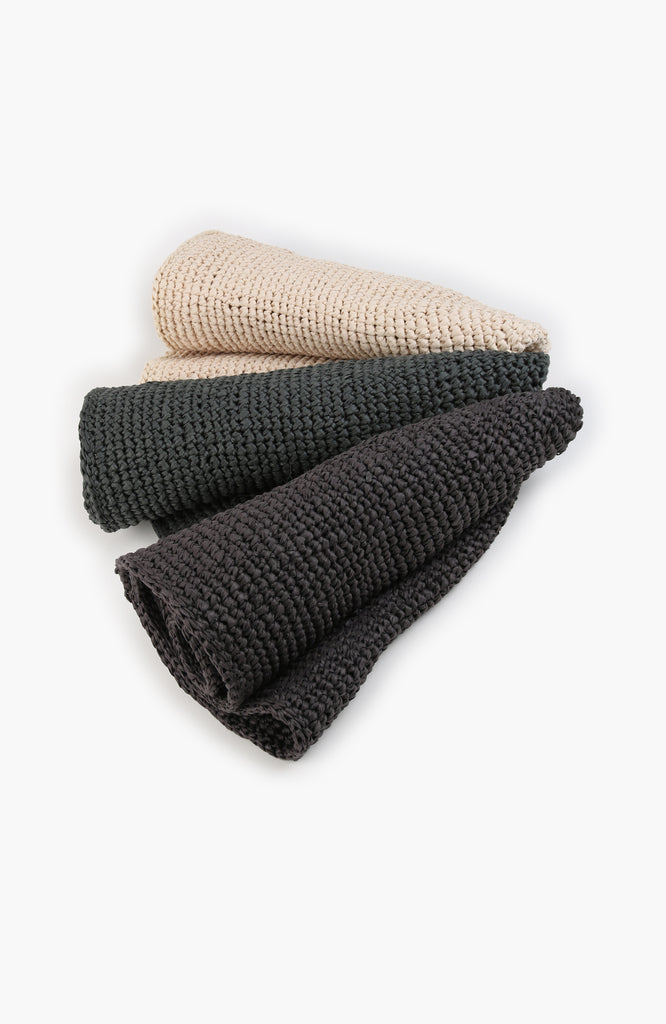 three crochet paper sun hats in charcoal, thyme and ivory colour from Karakoram Accessories rolled on white background