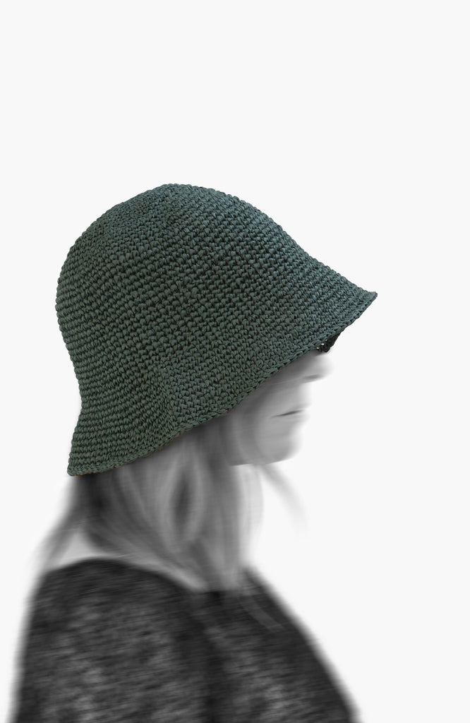 model wearing a crochet paper sun hat in thyme colour from Karakoram Accessories viewed from the side