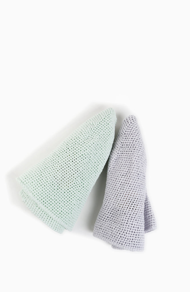 two crochet bell hats in mint and lavender colour from Karakoram Accessories rolled