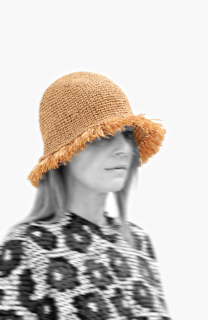 model wearing a crochet paper sun hat  in oak colour with fringed brim from Karakoram Accessories viewed from the side