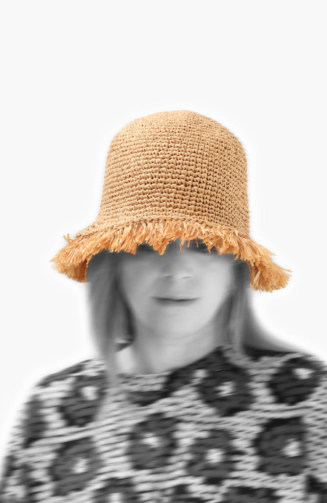 model wearing a crochet paper sun hat  in oak colour with fringed brim from Karakoram Accessories viewed from the front