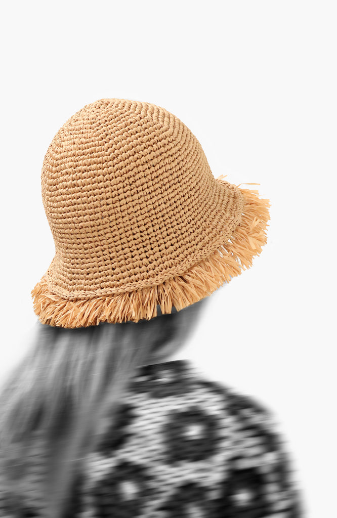 model wearing a crochet paper sun hat  in oak colour with fringed brim from Karakoram Accessories viewed from the back
